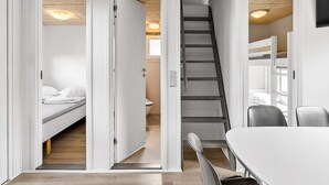 A compact room with a bunk bed, a desk with a chair, and a staircase leading to an upper level. - 8 Person Holiday Park Home in Faaborg (Faaborg)