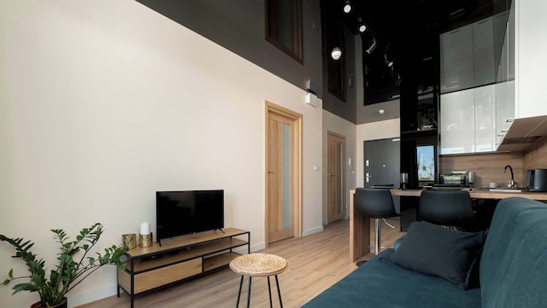 Una sala de estar moderna con televisor, sofá y comedor.