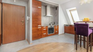 Eine Küche mit Holzausstattung, einer Edelstahl-Dunstabzugshaube und einem eingebauten Backofen.