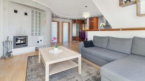 Ein modernes Wohnzimmer mit Kamin, einem grauen Sofa und einem Holztisch.