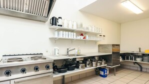 A modern kitchen with stainless steel appliances, white shelves, and a tiled floor. - 2 Person Holiday Park Home in Laeso (Læsø)