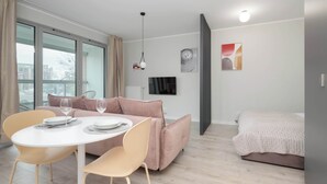 Un apartamento moderno con comedor, sofá, cama y televisor.