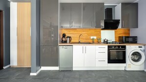 Una cocina moderna con electrodomésticos de acero inoxidable, armarios de madera y horno empotrado.