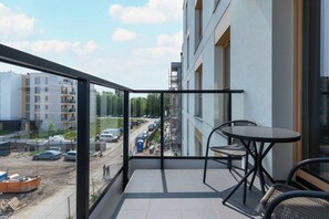 Un balcon donnant sur un chantier de construction, avec une table et des chaises.