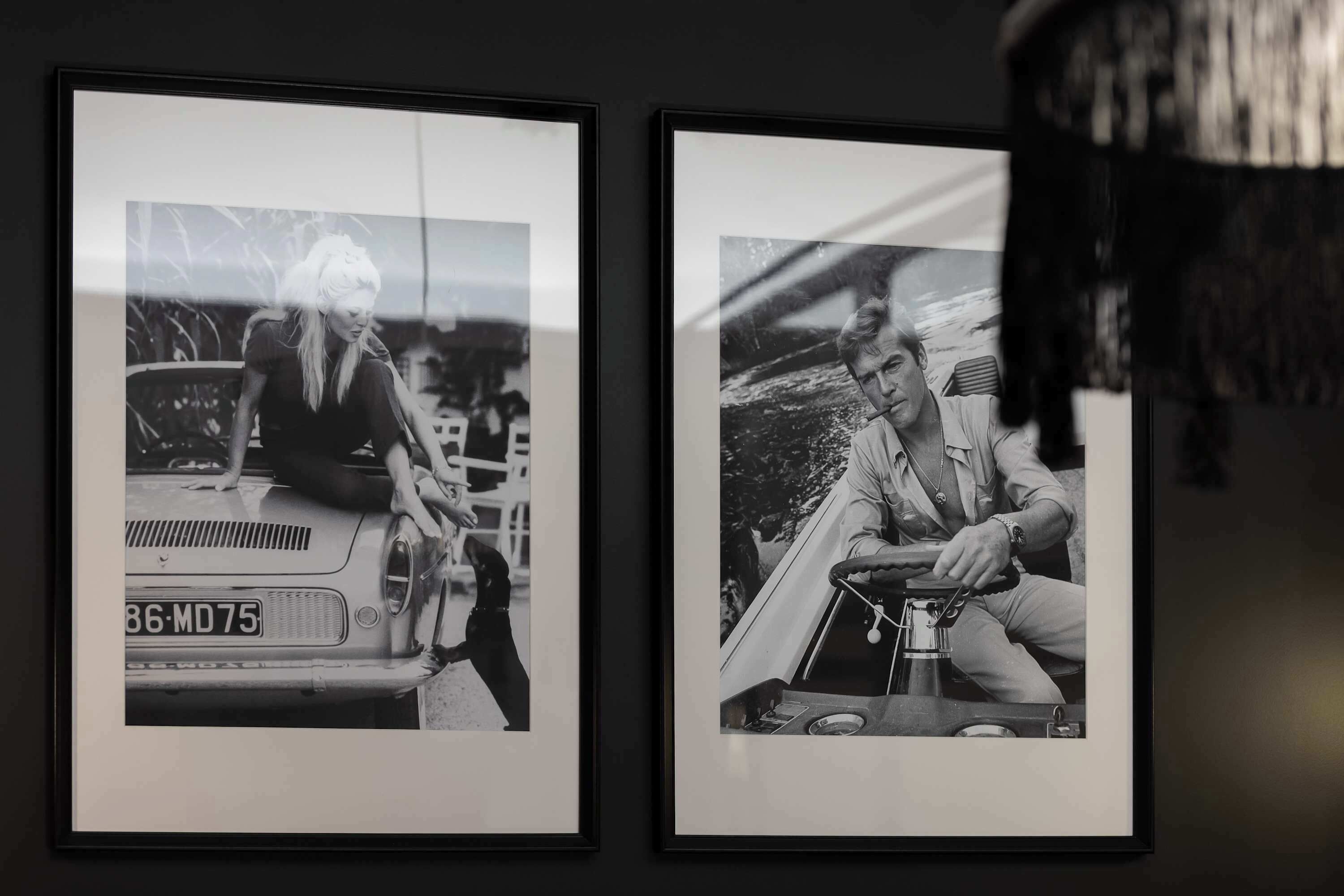 Zwei gerahmte Schwarz-Weiß-Fotos von Personen in einem Fahrzeug.