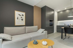 Un salon moderne avec un canapé, une table basse et une cuisine en arrière-plan.