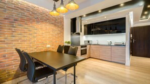Una cocina moderna con pared de ladrillo, armarios de madera y un comedor con mesa y sillas.