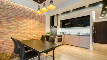 Eine moderne Küche mit Backsteinwand, Holzschränken und einem Essbereich mit Tisch und Stühlen.