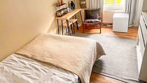 Makuuhuoneessa on sänky, työpöytä, tuoli ja patteri.