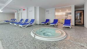 Un área de spa con un jacuzzi rodeado de sillones reclinables azules.