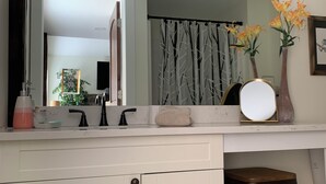 A bathroom vanity with a mirror, a sink, and a stool.