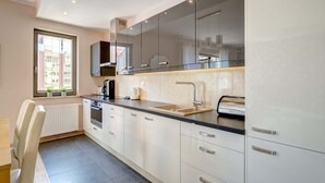 A modern kitchen with a large window, built-in appliances, and a sleek countertop.