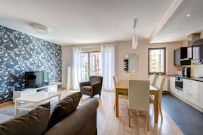 Una sala de estar moderna con televisor, sofá y comedor.