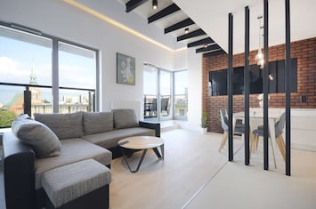 Spacious living room with a corner sofa bed, dining area and access to the balcony.