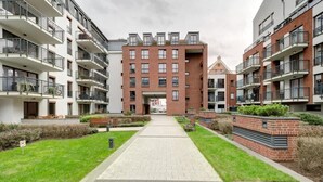 A multi-story residential building with balconies, a central courtyard, and a brick facade.