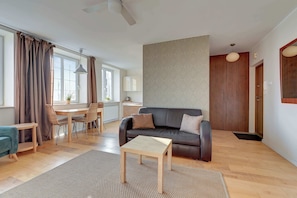Un salon moderne comprenant un canapé, une table basse, une table à manger et des chaises.