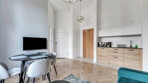 Une cuisine moderne avec des meubles en bois, un four encastré et une machine à café.
