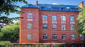 Un bâtiment en briques rouges, doté de nombreuses fenêtres et d’un toit bleu.