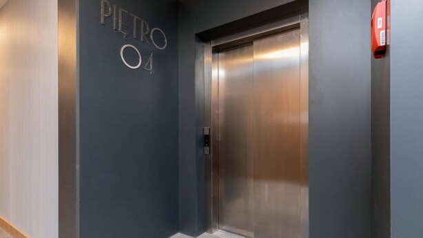 An elevator with a metallic finish and a digital control panel.