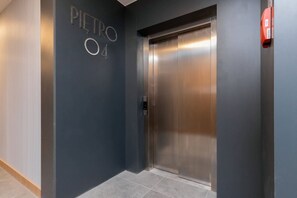 An elevator with a metallic finish and a digital control panel.