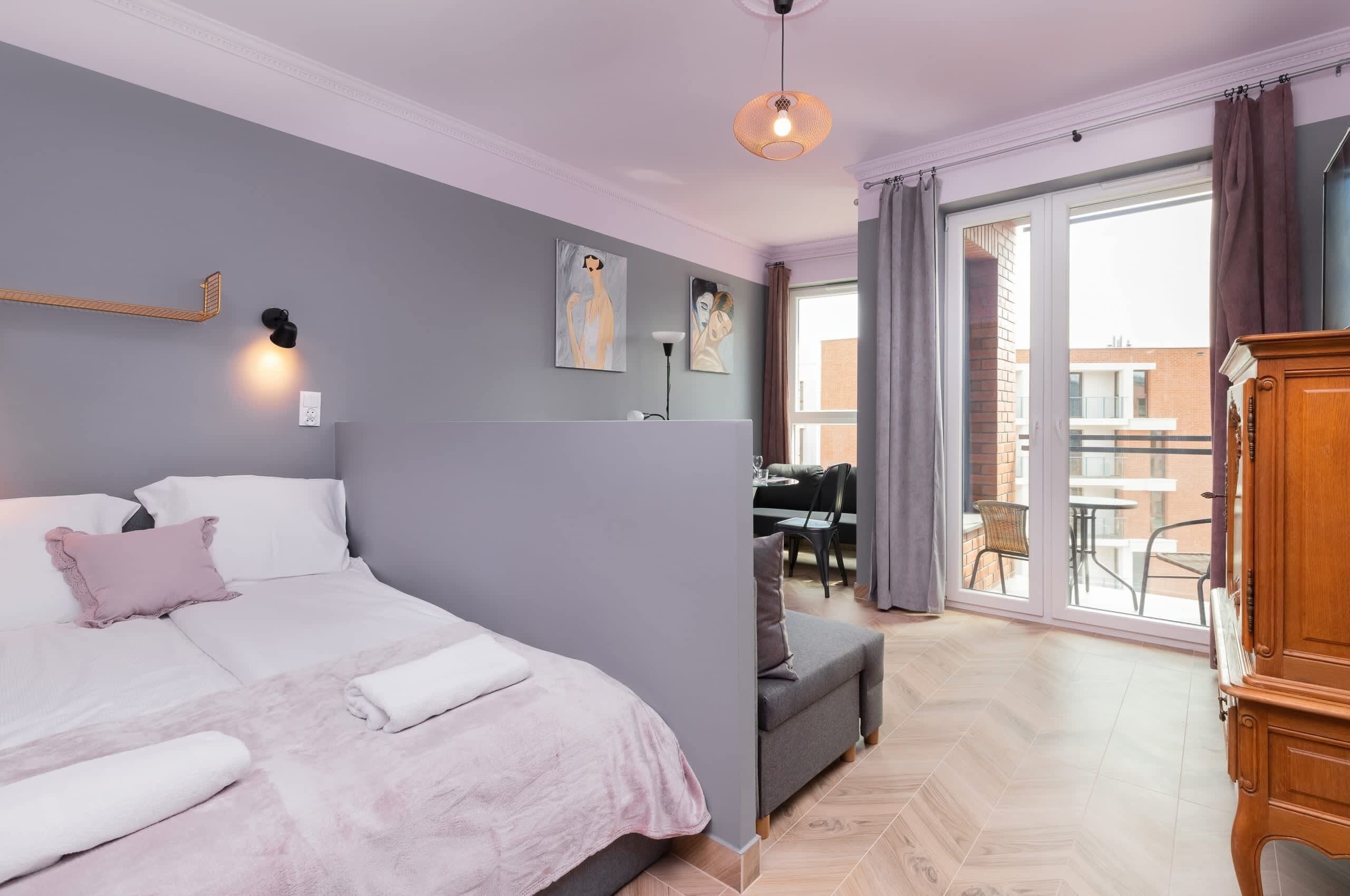 Een moderne slaapkamer met een groot bed, een bureau en uitzicht.