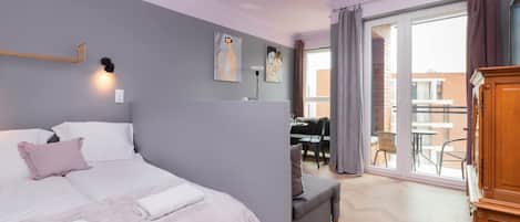 Un dormitorio moderno con una cama grande, un escritorio y vistas al exterior.