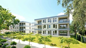 A modern multi-story residential building with a flat roof, large windows, and a well-maintained lawn with young trees.
