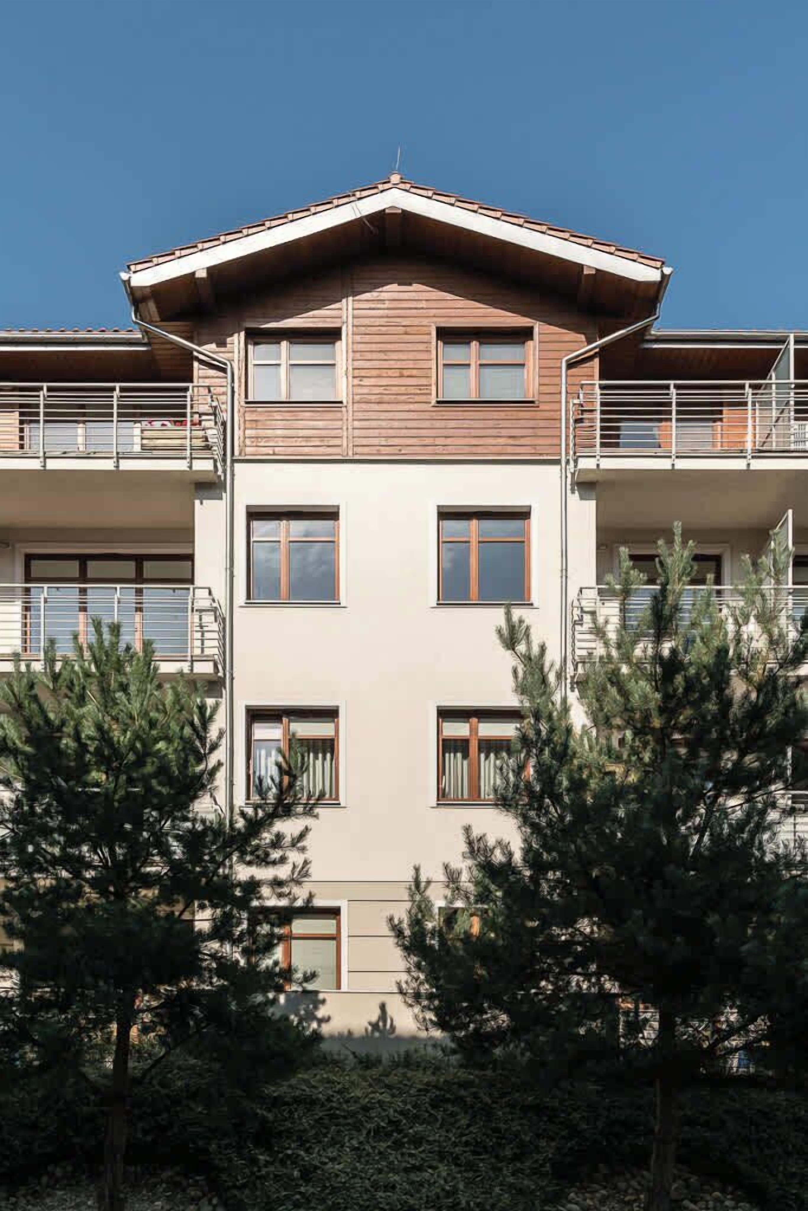 Un edificio de varios pisos con balcones, ventanas y fachada de madera.