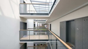 A multi-level interior with glass railings, a staircase, and a skylight.