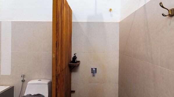 Ein Badezimmer mit Holzwand, Toilette, Waschbecken und Dusche.