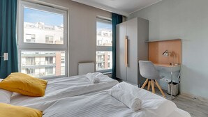 A hotel room with two beds, a desk, and a chair. - Comfortable Apartment in the Center | Remote Work (Gdańsk)
