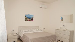 A bedroom with a bed, bedside tables, a dresser, and two wall-mounted pictures. - Cannavacciuolo house (Gragnano)