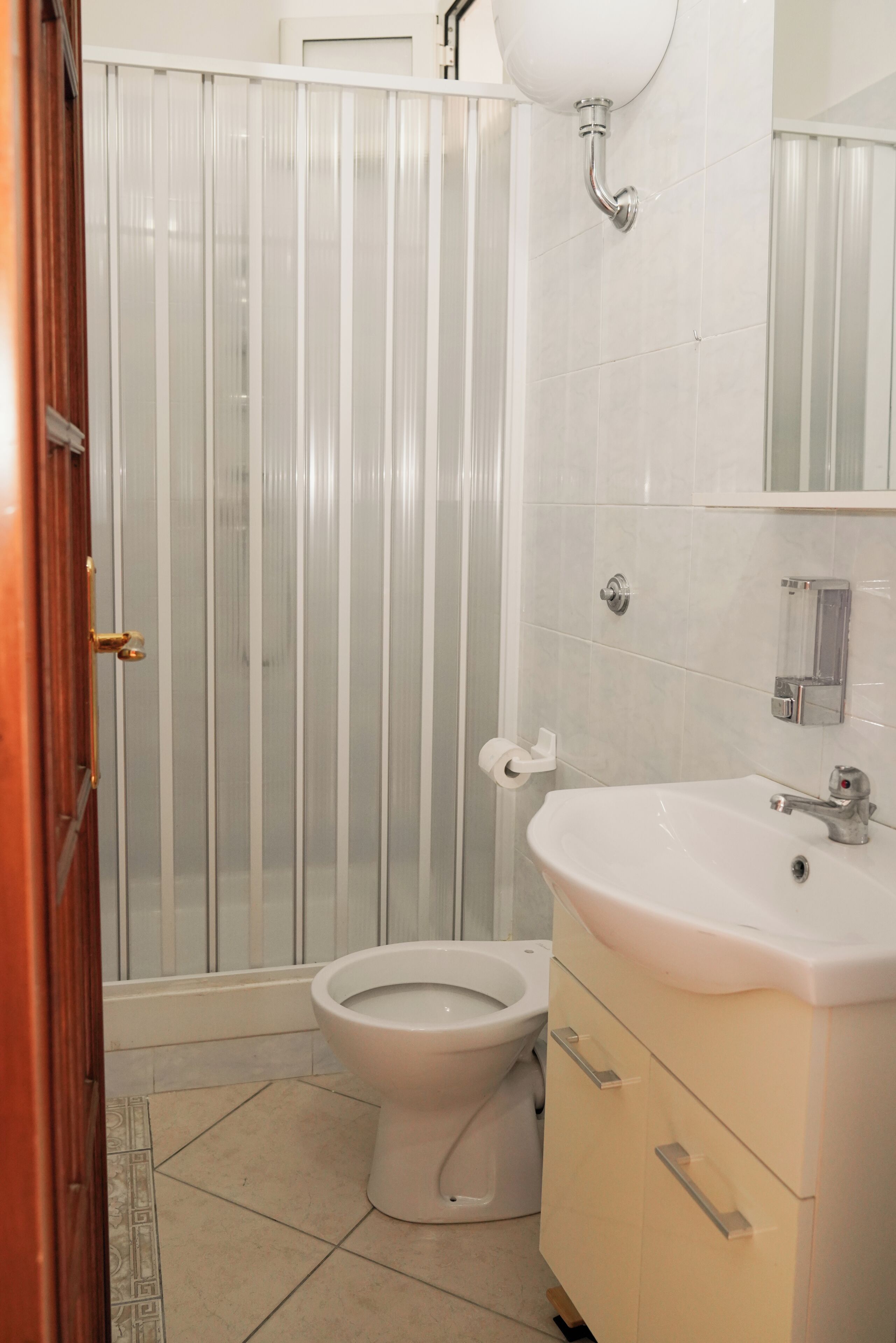 A bathroom with a toilet, a sink, and a shower enclosure.
