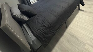Une chambre à coucher avec un lit, une table de chevet et une fenêtre avec des rideaux.