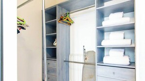 Un dressing avec de nombreuses étagères et des tiroirs, un chariot métallique et un radiateur.