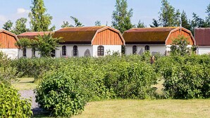 A row of white buildings with red roofs, surrounded by greenery. - 6 Person Holiday Park Home in Otterup (Otterup)