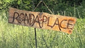 Un letrero de madera con el texto 'RONDA PLACE' en estilo rústico.