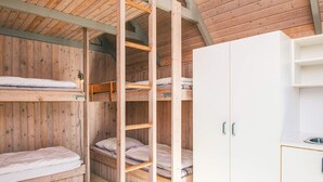A bunk bed room with wooden walls and a white wardrobe. - 6 Person Holiday Park Home in Pandrup (Pandrup)