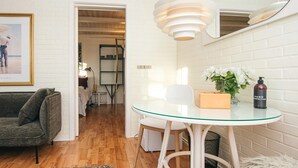 A modern living room with a glass table, a green sofa, and a white brick wall. - 2 Person Holiday Park Home in Fano (Fano)