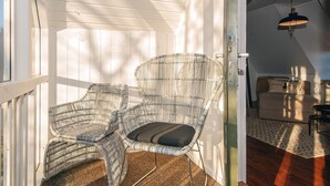 A cozy room with a wooden ceiling, a wicker chair with a cushion, a small table, and a bed with a pillow. - 2 Person Holiday Park Home in Fano (Fano)