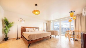 Habitación de hotel moderna con una cama grande, un escritorio y vistas a la ciudad.