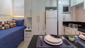 Une cuisine moderne avec des meubles blancs, un four encastré et une fenêtre au-dessus de l’évier.