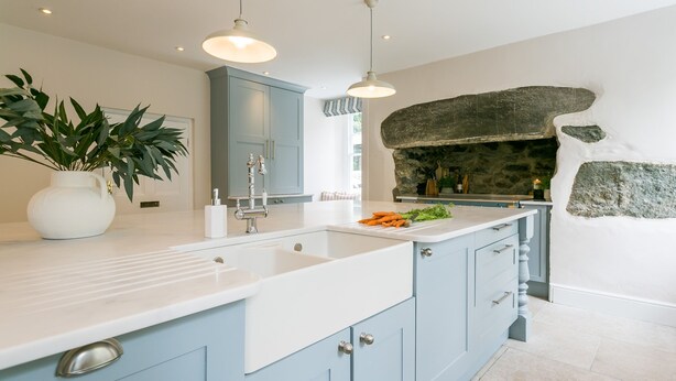 A modern kitchen with a white countertop, blue cabinets, and a stone backsplash. - Treiorwerth -  a dog that sleeps 15 guests  in 7 bedrooms (Heart of Anglesey)