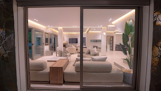 A modern living room with a sofa set, a coffee table, and a TV. - Cabo negro villa with large garden, swimming pool and barbecue area (Cabo Negro)