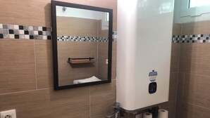 Ein Badezimmer mit Spiegel, Waschbecken, Handtuchhalter und Toilette.