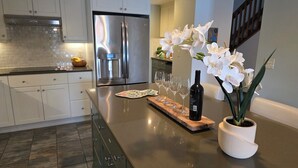 A modern kitchen with stainless steel appliances, a wooden countertop, and a potted orchid. - Smith Mountain Sunrise: Waterfront Party Deck, Great Water Views, & Hot Tub! (Huddleston)