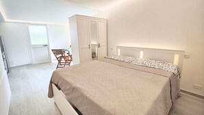 Un dormitorio con cama, armario y escritorio.