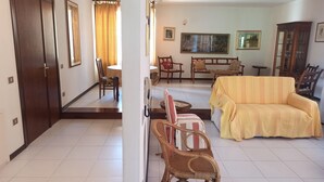 Un salon comprenant un canapé, des fauteuils, une table à manger et un buffet.
