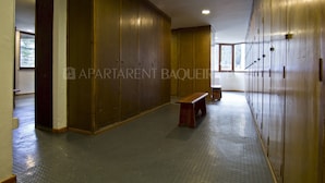 A hallway with lockers, a bench, and a window.