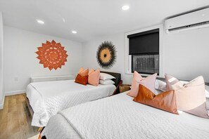 A modern hotel room with two beds, a large decorative wall piece, and a window with a view. - Hacienda Flamingo Unit 3 - Modern 1BR Hideaway with Double Queen Beds (West Palm Beach)